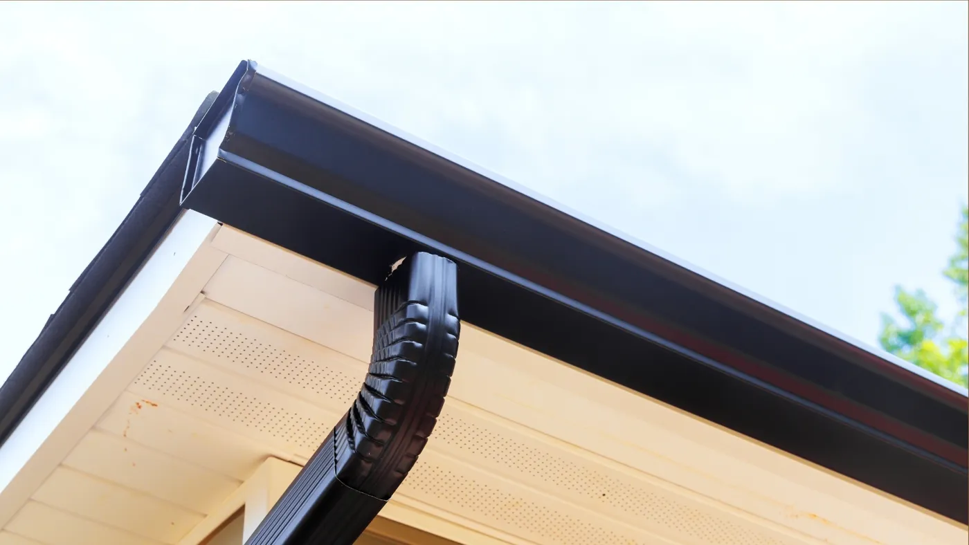 Black downspout on a white eave
